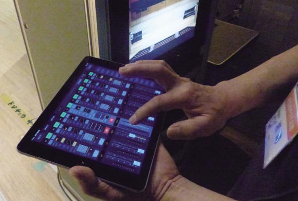 写真：舞台袖からiPadにて音を危機ながらフェーダー操作をする様子