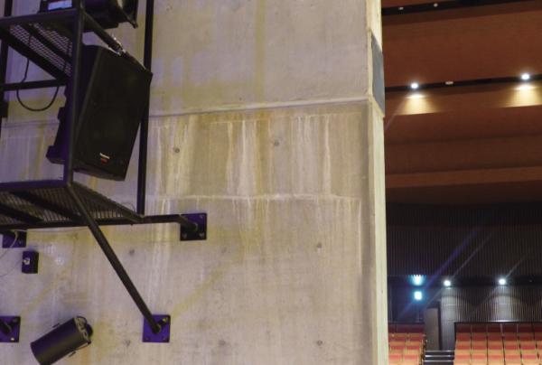 写真：舞台上に設置された固定ハネ返りスピーカー WS-AR200-K。舞台の書割裏に金属製のフレームを取付け設置されている。