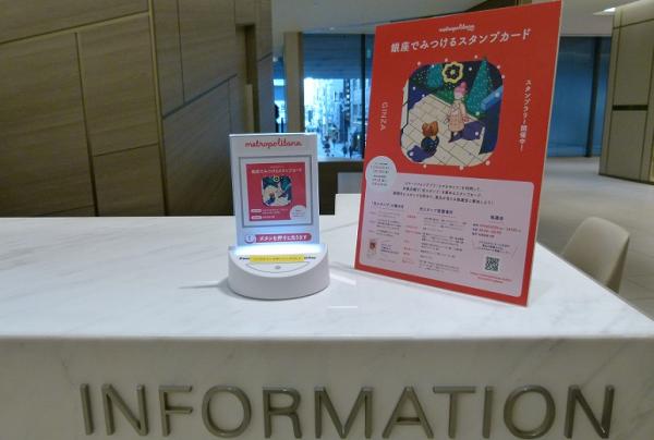 写真：インフォメーションコーナーの隅に設置されたLinkRay対応卓上発信機。案内係はおらず、発信機と詳細説明のPOPだけが置かれている。