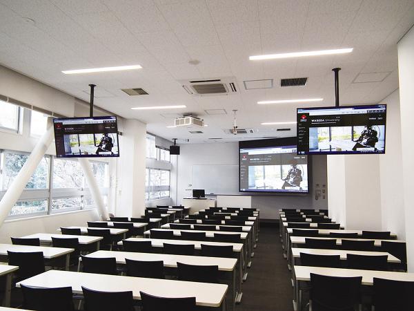写真：教壇に電動式の120型スクリーン、後方にサブディスプレイとして50V型液晶ディスプレイTH-50LEF7Jを設置