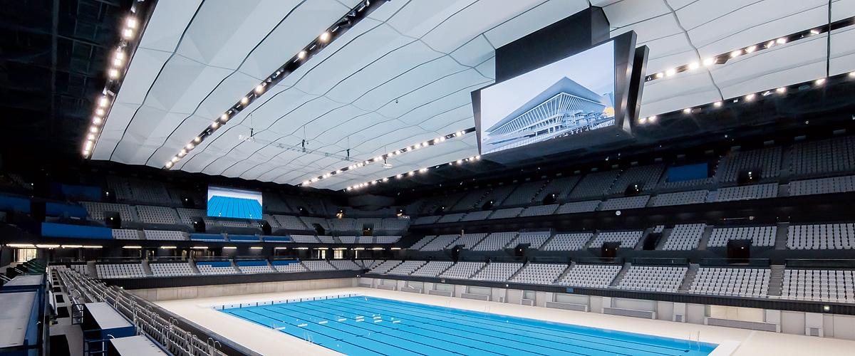 写真：東京アクアティクスセンター、メインアリーナの50m×10レーンの大型プールと客席上部に設置された大型映像表示装置。