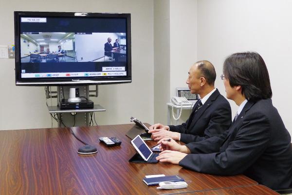 写真：本社の会議室と東京支店をつないだビデオ会議の様子
