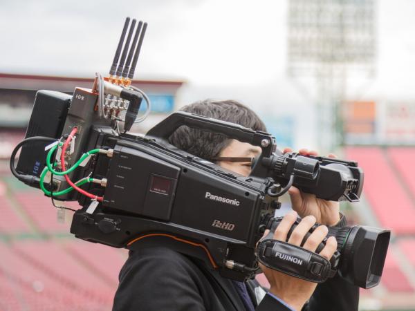 写真：ワイヤレスカメラ（P2ハンディカメラレコーダー AJ-HPX380型）演出用に球場内のいたるところを撮影し映像を伝送する