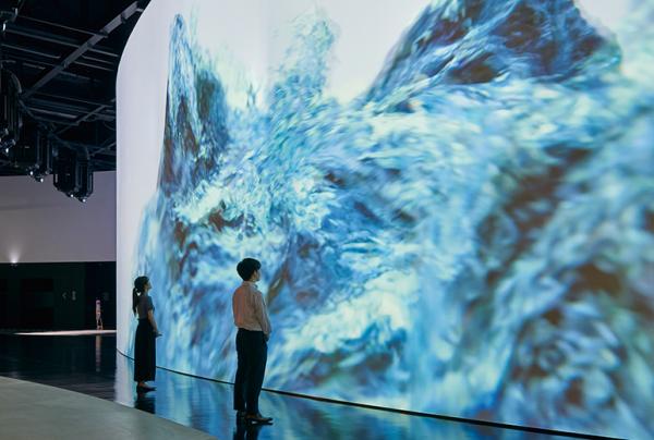 写真：人がスクリーンの壁面に近づいても影が映り込まない