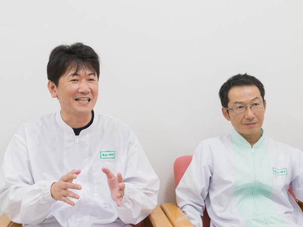 写真：キューサイ株式会社 SCM統括部 生産部  福岡こうのみなと工場 工場長 北村 洋様（右）  業務・生産管理課 課長 荒川浩二様（左）