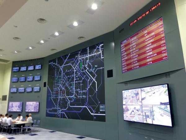 写真：管制センターは吹き抜けの高い天井になっている。一番低輝度となる「ロングライフ3」モードで運用されているが、明るい室内でも充分に鮮明な表示を実現。室内の端からでも各種情報をはっきりと確認できる