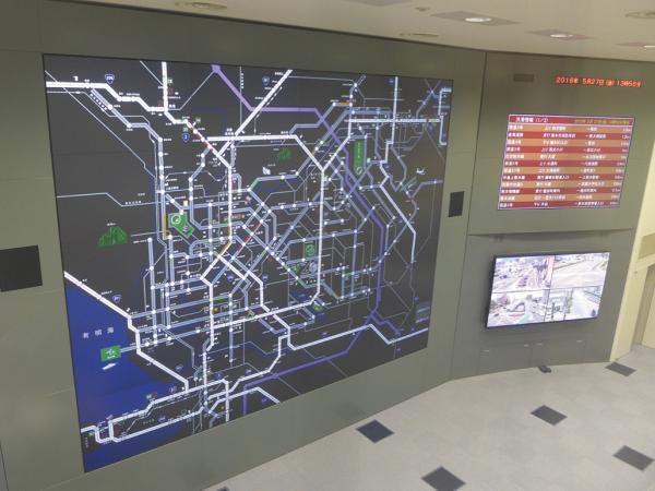 写真：上階にある庁舎見学コースから見た管制センター。ガラス越しからでも、鮮明な表示を実感できる
