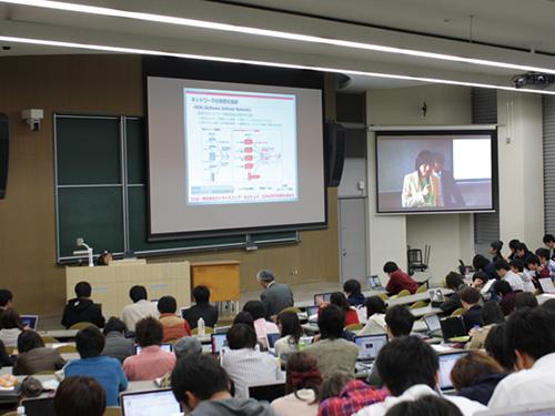 写真：Ω（オメガ）館の大講義室にて行われている遠隔講義。写真は、広島市立大学大学院の前田香織教授の司会の様子