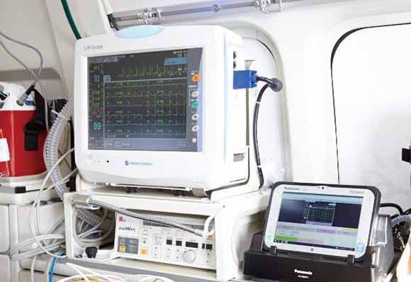 写真：救急車内では、FZ- M1をクレードルに設置し、心電図モニターと有線接続。心電図もリアルタイムに伝送。