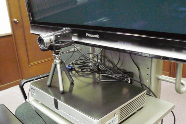 写真：HD映像コミュニケーションユニットKX-VC500の上にデジタルビデオカメラHDC-TM350を三脚で固定して使用しています。