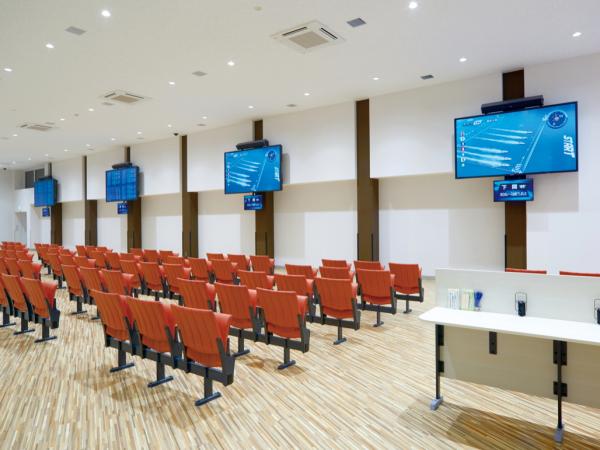 写真：一般席の壁面にTH-98LQ70Jを4台設置。1台につき1場分の情報を表示している