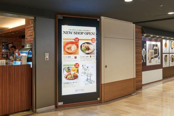 写真：飲食街「博多デイトス」の入り口では80V型のデジタルサイネージで店舗・メニュー情報を大きく紹介