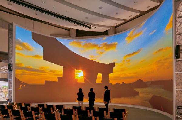 写真：高さ7 m×幅18 ｍの巨大な半円形のスクリーンに、海の正倉院といわれる沖ノ島の臨場感ある映像が常時映し出されている