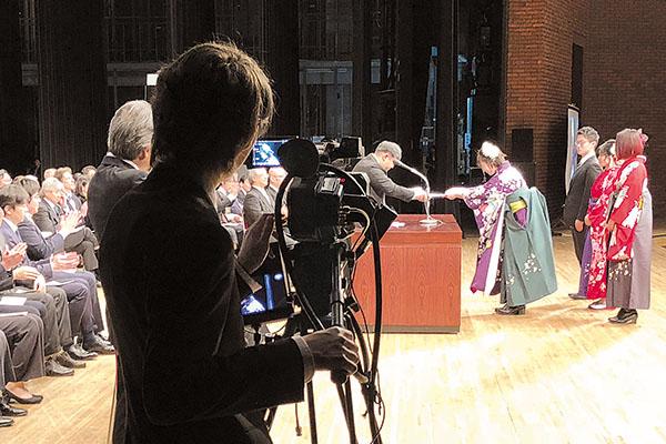 写真：2018年3月に行われた卒業式でのライブ配信テストの様子。カメラマンは学生スタッフ