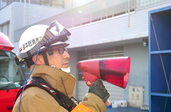 写真：指揮隊員とウェアラブルカメラ 情報共有に要する時間が軽減された分、指揮隊員は近隣住民の方への広報など現場活動をより手厚く行えるように。