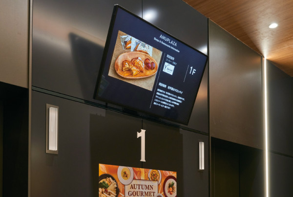 写真：各階のエレベーターホールや、エスカレーター上部にも映像を表示させ、来店客が移動中にも情報が受け取れるよう設計されている