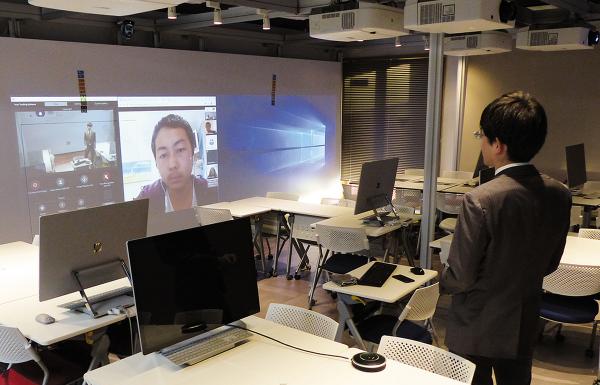 写真：壁面スクリーンの上に設置したHDインテグレーテッドカメラAW-HE70HK9で教師を自動追尾して撮影。オーストラリアに留学中の生徒11名と同時接続した遠隔授業の様子