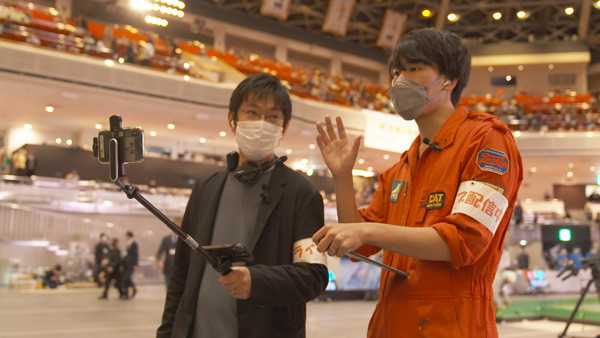 写真：スマートフォンの活用で会場内を自由に動き回りレポート