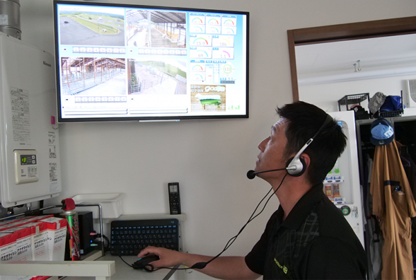 写真：3棟の牛舎と外の様子が1台のディスプレイで確認でき、指示出しも簡単