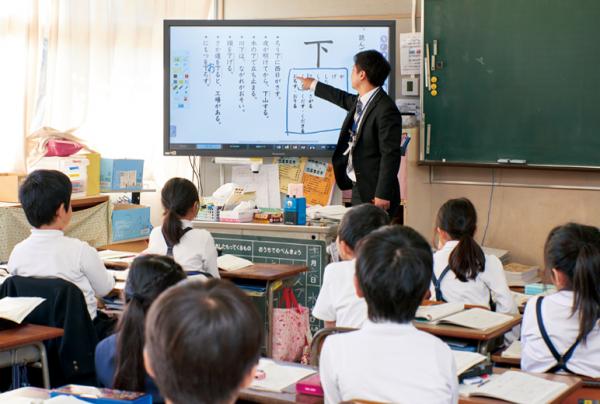 写真：国語の授業中の様子。タッチスクリーンディスプレイに映し出された教材に書き込む教諭。