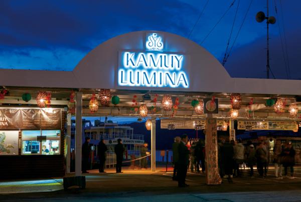 写真：日が暗くなり発着所のゲートの『KAMUY LUMINA』部分が点灯する様子。