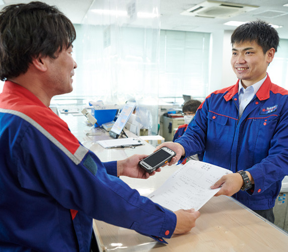 写真：オフィスで端末と指示書を受け取り業務開始。