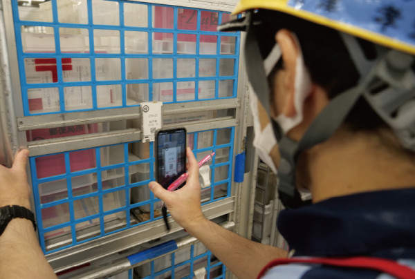 写真：二次元コードを読み取る様子（局員）