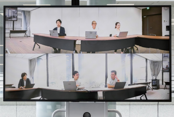 写真：「AP東京丸の内」の“コの字型”の会議室に6名着席して撮影し、上下180度ずつの「全周ビュー」で表示した様子。どの席に座っても表情までしっかり伝わると利用者様から好評。