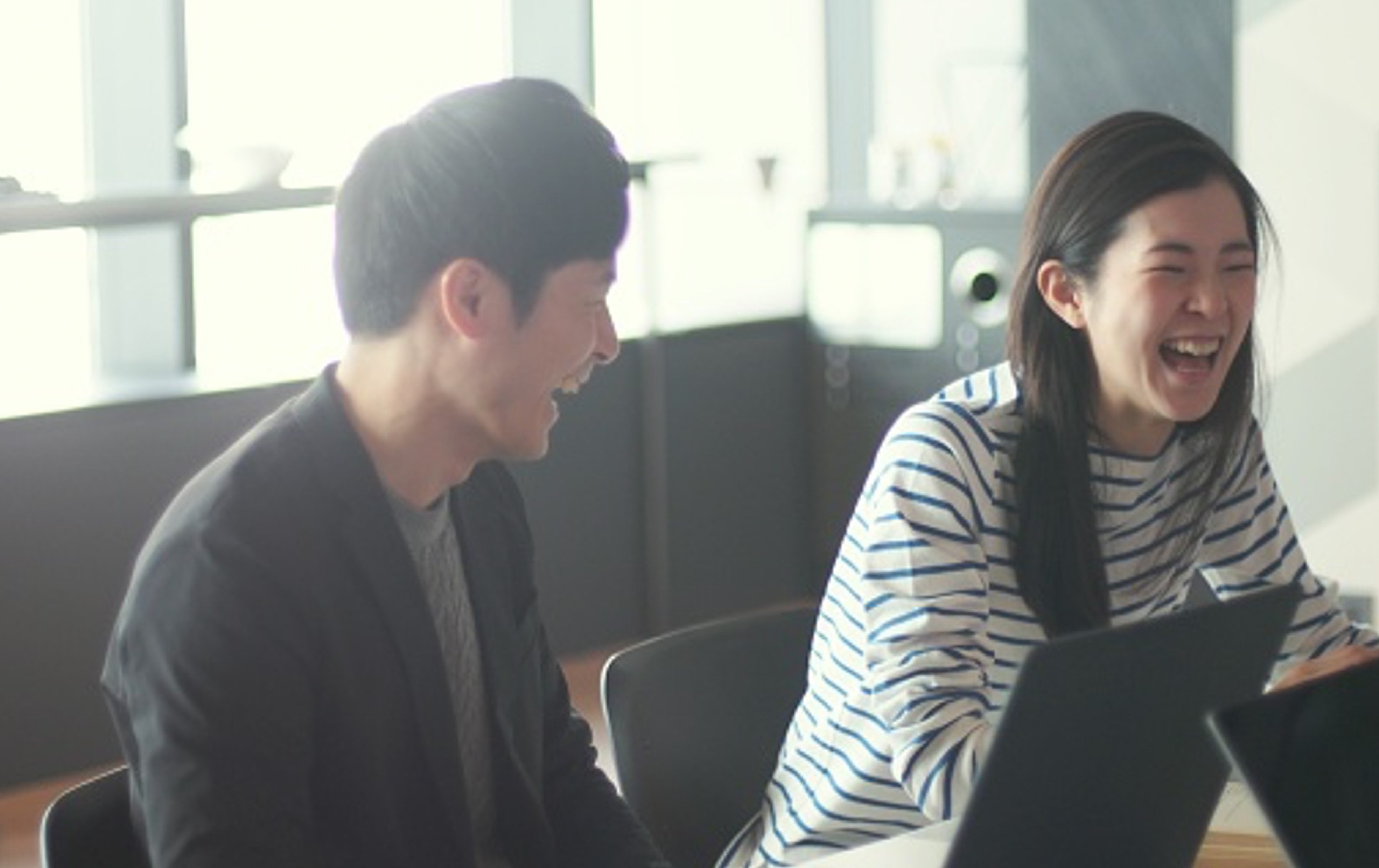 ミーティングルームで楽しそうに談笑している男女