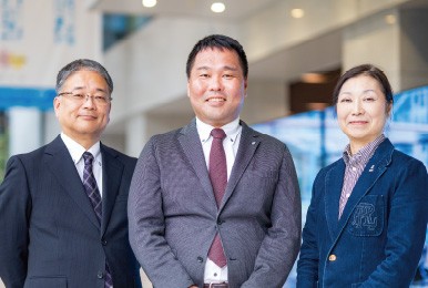 学校法人常翔学園　大阪工業大学　ロボティクス＆デザイン工学部事務室長　兼　総務部付社学連携担当課長　金築 雄吾様（写真左）ロボティクス＆デザイン工学部事務室　係長　澤井 浩子様（写真右）喜多 健太郎様（写真中央）※所属は納入時のものです。