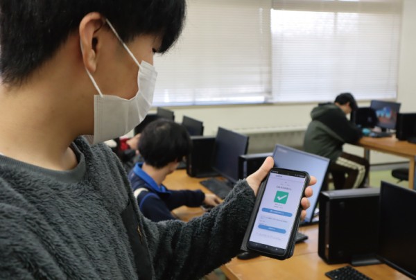 教室で出席登録をする学生の様子。