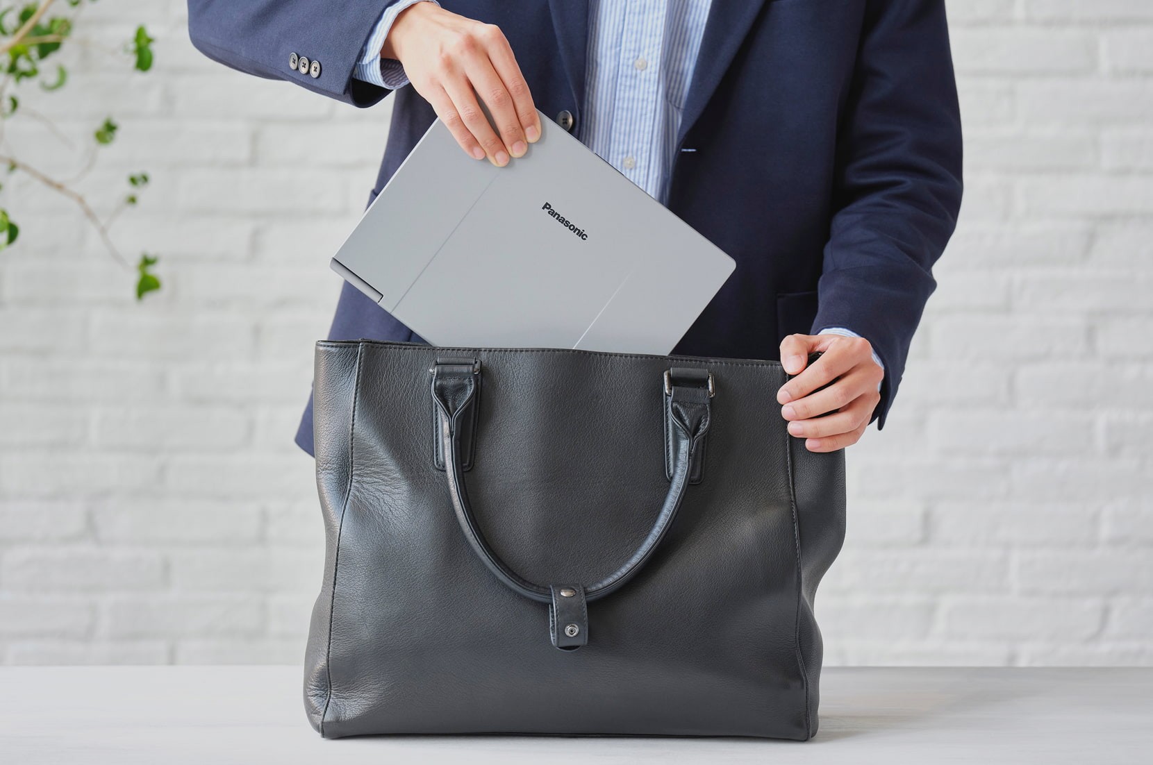 レッツノートの背面半開きの様子。軽量と頑丈性を兼備するマグネシム合金素材が強調されている