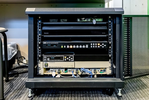 サイネージコントローラーやスイッチャー、分配器、フレームシンクロナイザーなどが格納されたラックは、場所を取らずに設置可能。