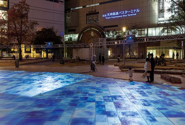 投写映像と公園の石畳の目地をできるだけ合わせており、映像が床面に自然に広がって見える。