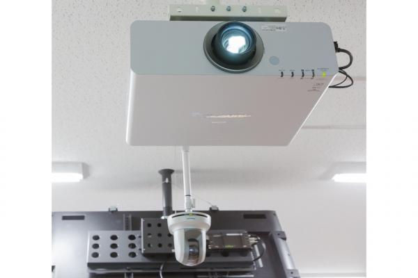 写真：天井面に設置されたプロジェクターとHDカメラ。HDカメラは2台設置し、講義収録やTV会議に使用