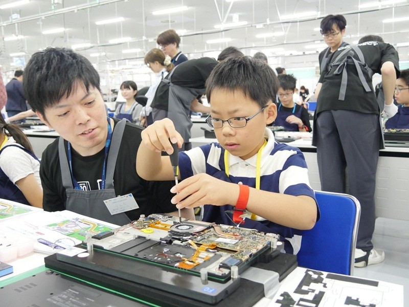 子供がレッツノートの部品の組み立てを大人と一緒に学ぶ。