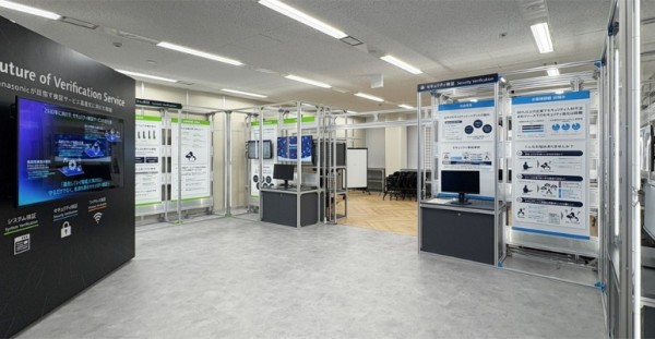 展示ブースが並ぶ明るい室内、モニターとポスターが配置された科学技術展示会の様子。