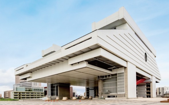 白いモダンな建物が青空の下に建つ大きな構造物。