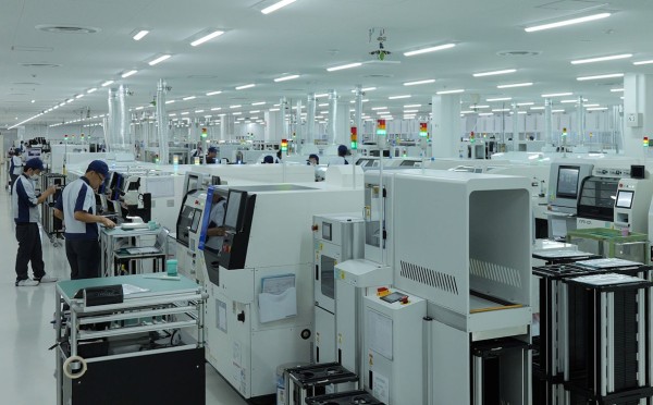 広々とした工場内で機械を操作する作業員たち