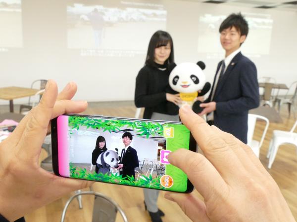 写真：ぬいぐるみを抱っこしてスマートホンでかざすと、シャンシャンの立体CG画像が画面に表示される