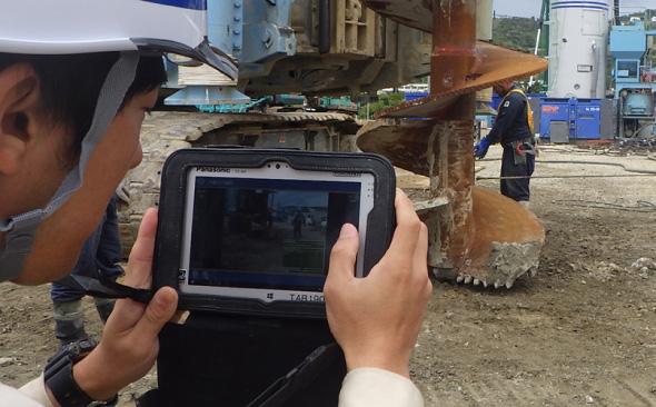 写真：杭基礎工事の現場にて、タフパッドを使用し撮影している様子。