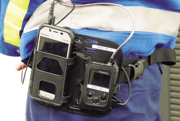 写真：作業員の腰元にベルトで装着されたタフパッドとウェアラブルカメラ本体部。