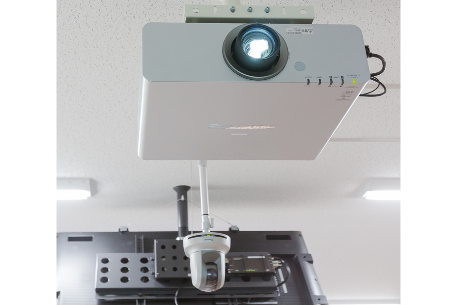写真:天井面に設置されたプロジェクターとHDカメラ。HDカメラは2台設置し、講義収録やTV会議に使用