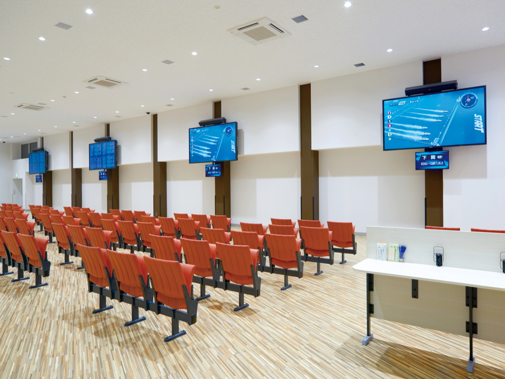 写真:一般席の壁面にTH-98LQ70Jを4台設置。1台につき1場分の情報を表示している