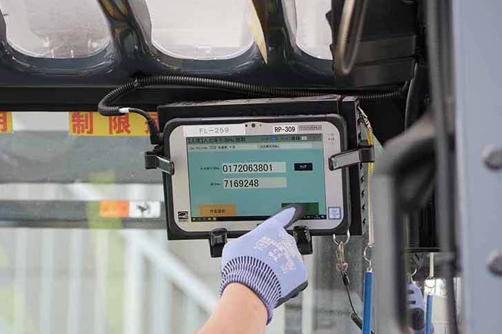 写真:FZ-M1を、フォークリフトの運転席の右上に設置。運転手は手袋のまま操作が可能。「冬の北海道など、手袋が必須の現場も多いので手袋操作モードは魅力でした」と佐藤様。
