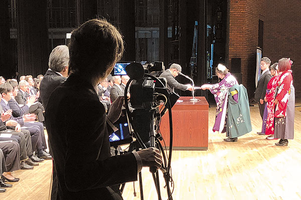 写真：2018年3月に行われた卒業式でのライブ配信テストの様子。カメラマンは学生スタッフ