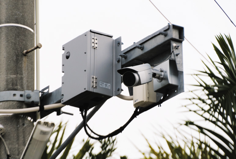 写真：電柱上部に設置されたた防犯カメラシステムとネットワークカメラ用60 GHz通信BOX。