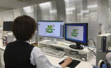 写真：PC画面を見る従業員